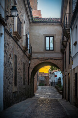 Fototapeta premium Vista panorámica del casco histórico de la ciudad española de Cáceres con vistas a los tejados de tejas marrones de edificios antiguos alrededor de la plaza principal en el soleado día de primavera