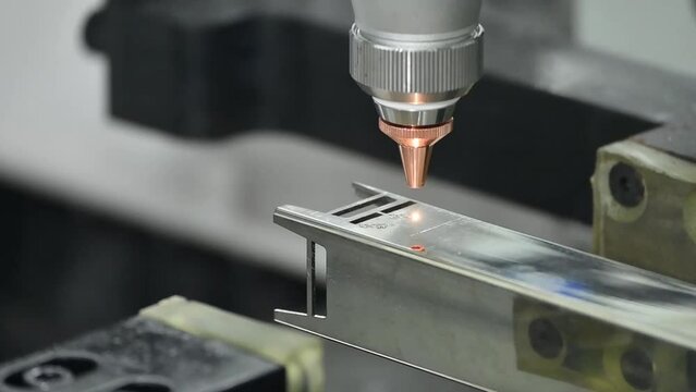 Close up scene the fiber laser cutting machine cut the stainless steel square tube and sparkling light.