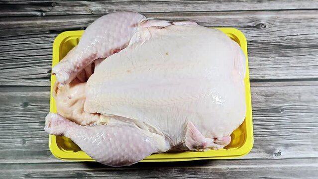 Fresh raw chicken with skin and bones, the whole chicken with breasts, legs, thighs, chicken meat that is ready for baking, grilling, barbecuing, frying or boiling, chicken white meat, selective focus
