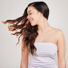 Haircare, smile and shine in studio, woman and growth with treatment from salon, happy and texture. White background, flipping and glow of hair, hairstyle and person with cosmetics of shampoo