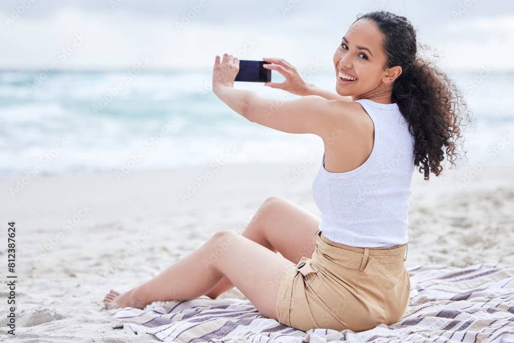 Poster Beach, smile and portrait of woman with phone for holiday, travel blog and photography of ocean. Happy, photographer and picture with smartphone on sand for adventure, social media post and update