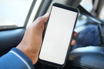  hand holding smart phone with empty screen in a car 