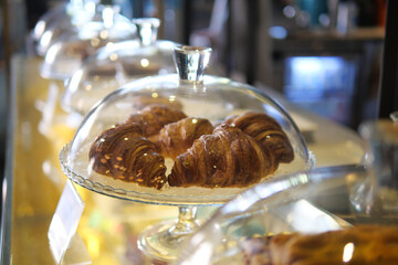 vertical sho or fresh baked croissant in a glass transparent container at shop 
