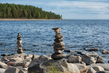Several pyramids of stones on the shore of Lake Ladoga. You can see the undulating water surface...