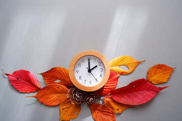 Daylight Saving Time concept background. 
Fall Back decoration colorful leaves and clock...