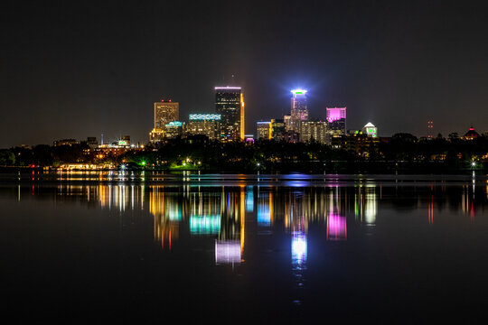 Minneapolis skyline at night reflecting off the waters of Lake Bde Maka Ska in Minnesota on a clear summer night