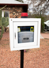 Aed, Life Saving Defibrillator In Street. Portable Automated External Defibrillator Outdoor. Cactus Is On Background. Vertical Plane. Prevention Of Heart Attack. Cardiac Healthcare. 