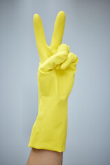 Cleaning, latex and peace sign with hand for chores or housework in studio on white background. Emoji, hospitality and person in rubber glove for hygiene, protection and safety from bacteria germs