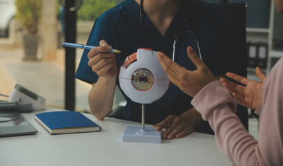 Ophthalmologist doctor in clinic, part of eye model on desk, oculus sample