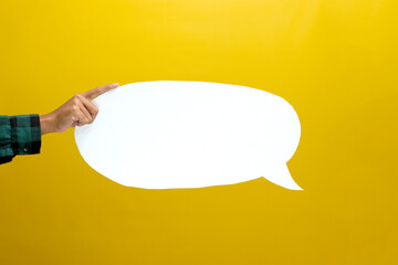Hand Holding a White Speech Bubble with Copy Space, Isolated on a Yellow Background