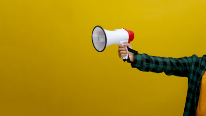 Hand Holding a Megaphone, Isolated on a Yellow Background
