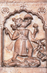 An ancient bas-relief of hindu deity made of stone carved on the wall of a palace in Jaipur, India