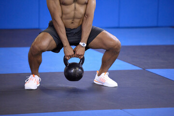 Man, kettlebell and squat in workout at gym, weightlifting and training for power or strong legs....