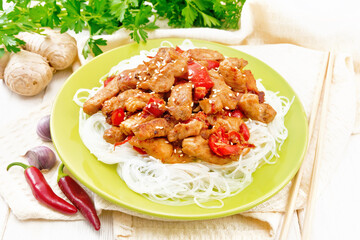 Stir-fry of chicken with peppers in plate on board