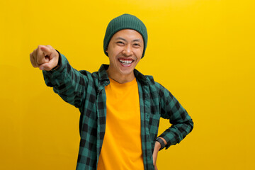 Its you. Young Asian man, dressed in a beanie hat and casual shirt, smiles while pointing his...