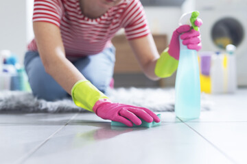 Woman scrubbing the floor with a sponge
