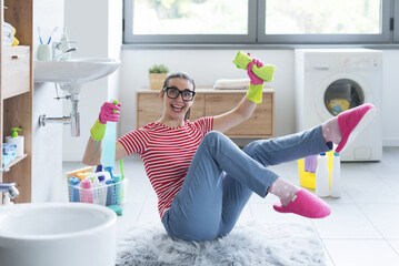 Cheerful happy woman cleaning up her home