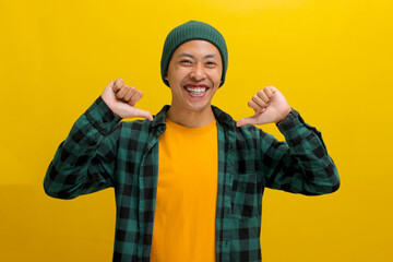Confident young Asian man in casual outfit and a beanie hat proudly points at himself with a happy...