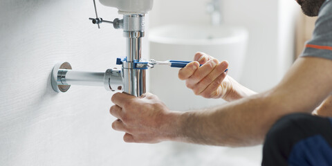 Professional plumber fixing a bathroom sink