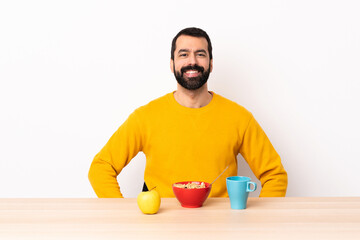 Caucasian man having breakfast in a table laughing.