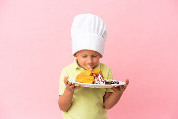 Little Russian boy holding waffles over isolated background
