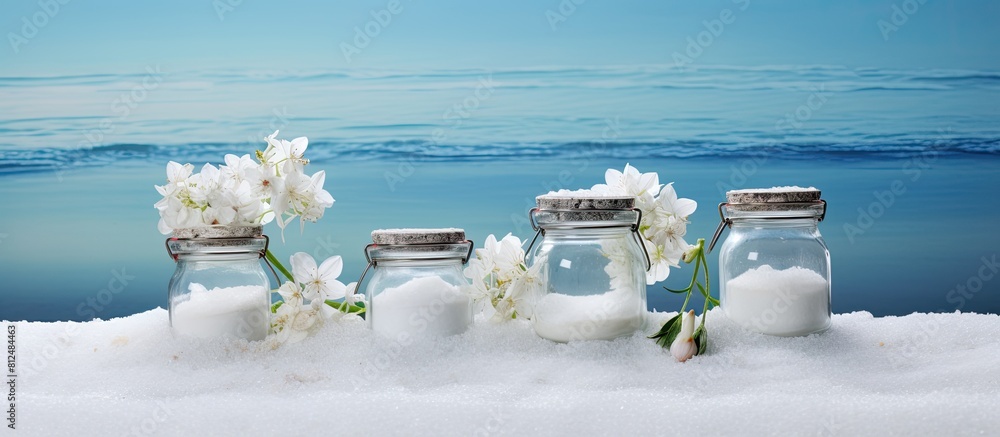 Poster on the table there are three banks containing sea salt and flowers creating a copy space image
