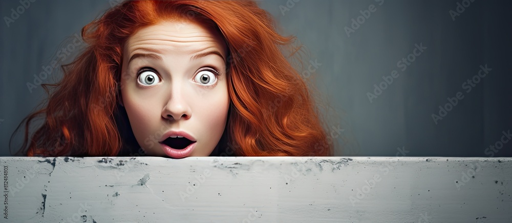 Sticker Astonished red haired girl holding a white board expressing great surprise with an open mouth Perfect for copy space image