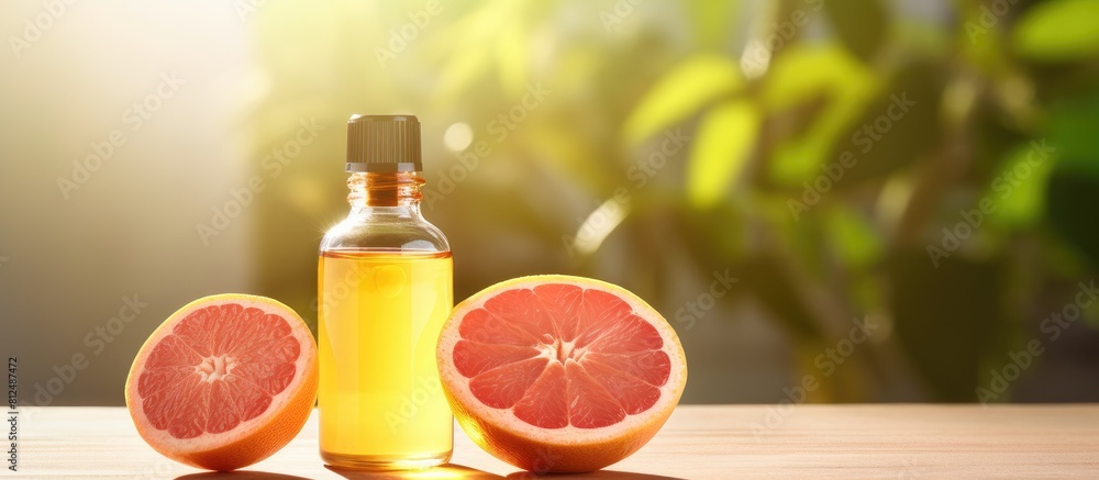 Aufkleber Close up photo of grapefruit essential oil in a bottle alongside a fresh fruit placed on a well lit table There is empty space available for adding text. Creative banner. Copyspace image
