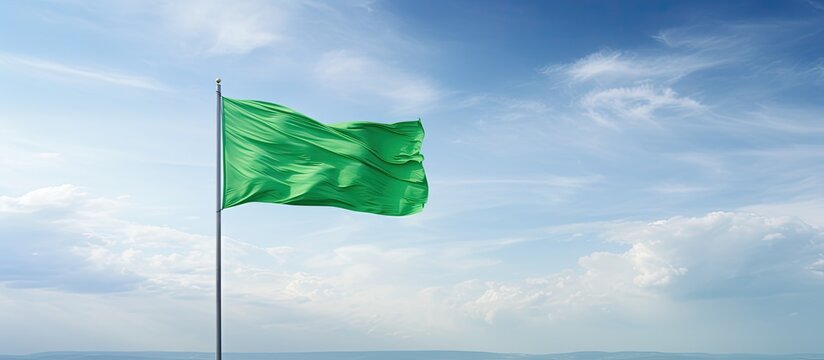 A close up view of a green flag against a scenic sky background providing ample copy space for additional content