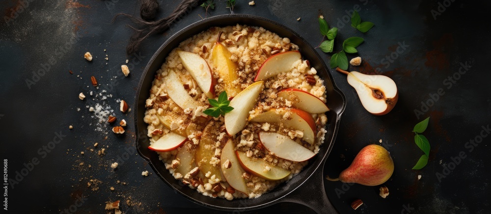 Poster A top down view of a delectable crumble made with oats cinnamon and pears adorned with hazelnuts and drizzled with honey It sits in a dark brown stone concrete frying pan offering ample copy space fo
