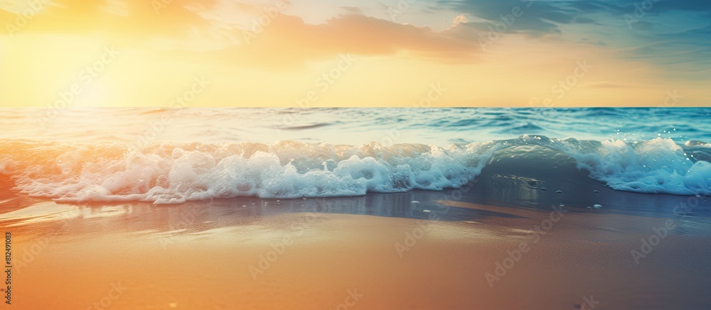 Poster blurry tropical sunset beach with the bokeh effect of sunlight on the waves creates an abstract back