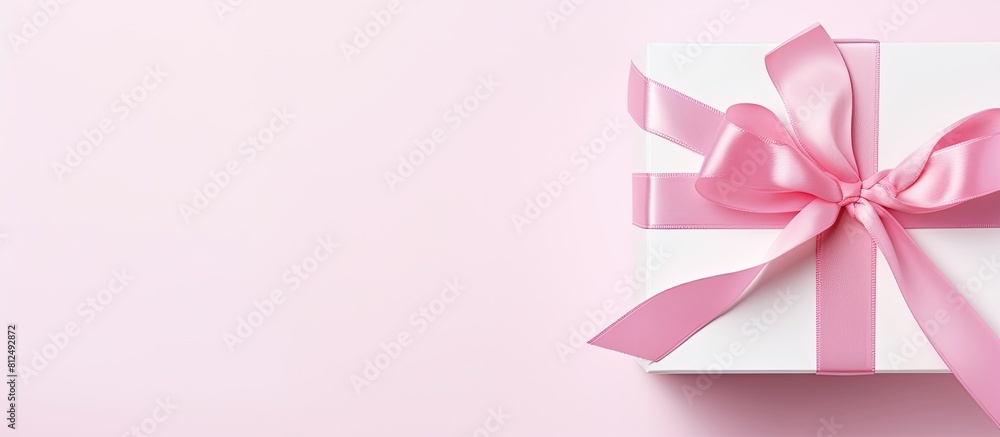 Aufkleber A flat lay image showing a white gift box adorned with a pretty pink ribbon placed on a clean white background with ample copy space available
