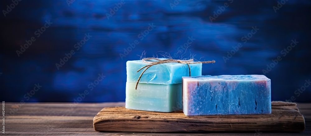 Poster Handcrafted soap displayed on a rustic blue wooden table creating a visually appealing copy space image