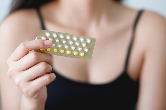 Woman hands opening birth control pills in hand. eating Contraceptive pill. Contraception reduces childbirth and pregnancy concept.