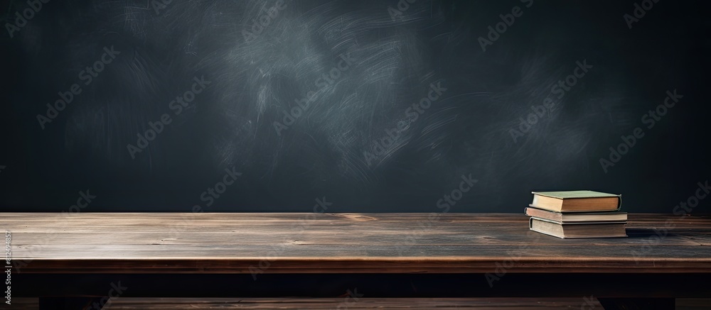 Poster a copy space image of an open book on a wooden school desk with the school blackboard background