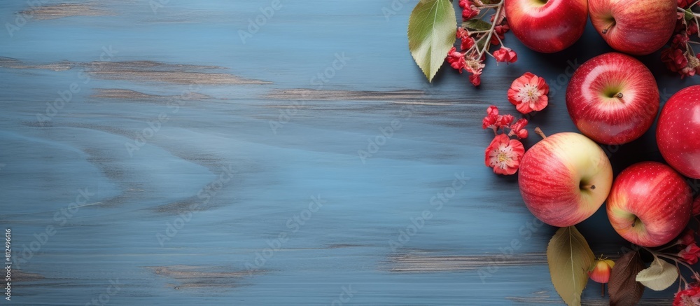 Aufkleber A copy space image featuring a rustic wooden board adorned with a heart leaves and an arrangement of vibrant red apples set against a backdrop of a serene blue background