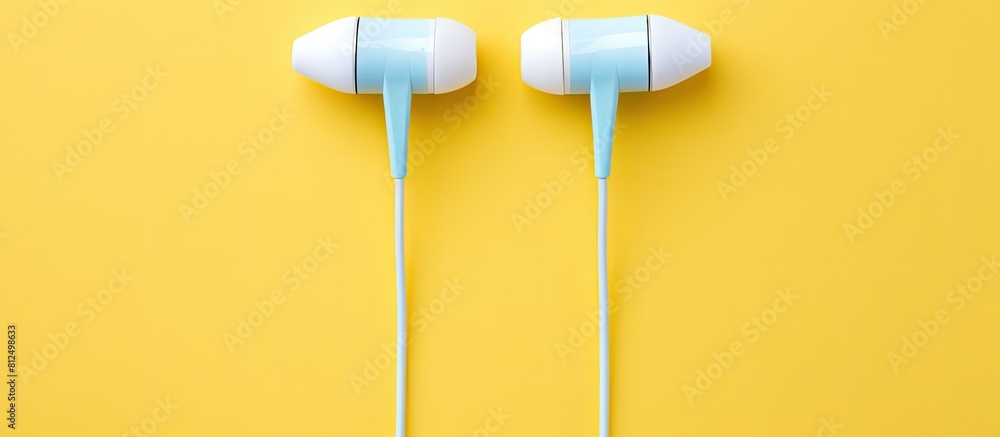 Poster a copy space image showing white wired earbuds placed flat on a vibrant background as seen from abov