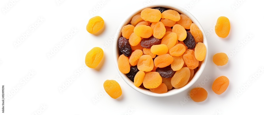 Aufkleber Copy space image of a top view bowl filled with dried apricots on a white background offering a healthy and nutritious fruit option