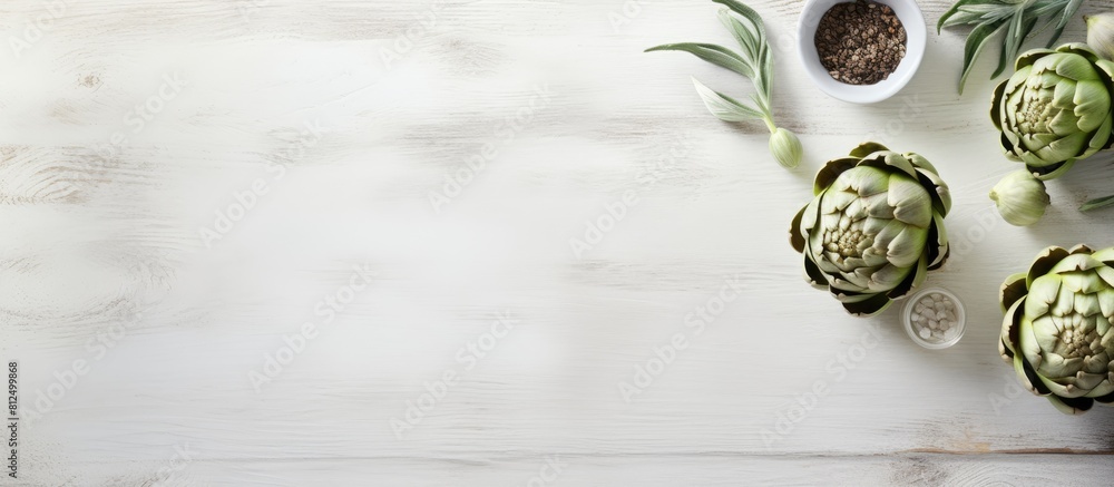Poster The white wooden table is adorned with a bowl filled with powder and fresh artichokes creating an appealing flat lay composition Ample space is available for text