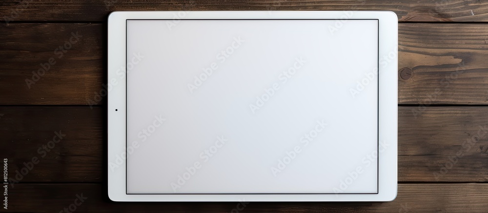 Leinwandbilder a white digital tablet is placed on a dark wooden table creating a contrast in colors and textures. 