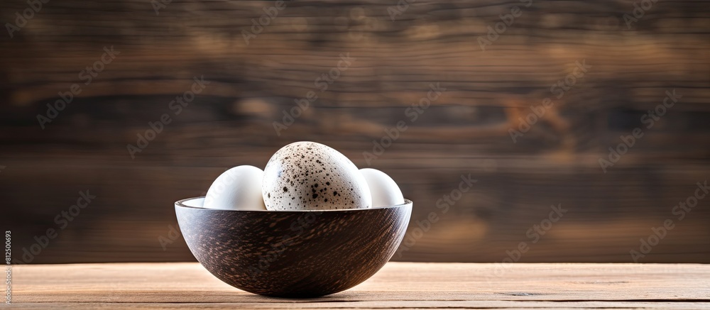 Poster a quail egg is placed in a bowl on a wooden table providing an ample amount of copy space for text o
