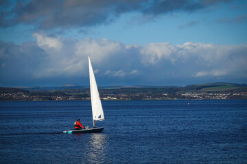 Sailboat is sailing in the Lake under a blue sky