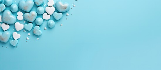 Pastel azure background with a heart shaped arrangement of blue sweet chocolates Flat lay top view Perfect for expressing love on occasions like Valentine s Day Mother s Day or a birthday card with c