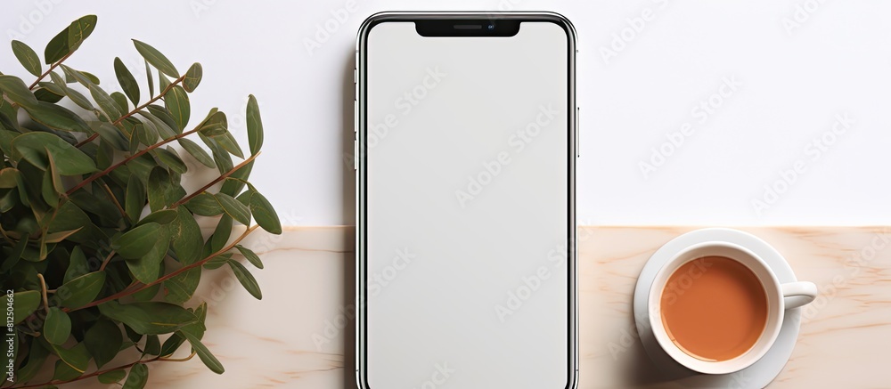 Poster a phone mockup rests on a white table accompanied by a cup of coffee and leaves creating a visually 