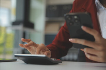 Asian businesswoman in formal suit in office happy and cheerful during using smartphone and working