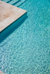 Obraz premium Large swimming pool with clear blue water and steps leading into the water. 