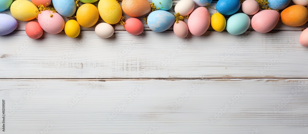 Poster easter themed background featuring colored eggs and a blank frame mock up on a light wooden surface 