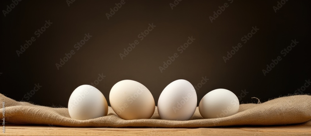Poster Three white eggs arranged on a piece of sacking in a copy space image