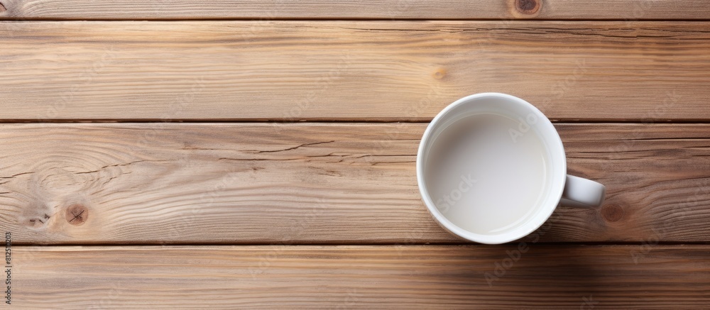 Poster Top view of a white cup placed on a wooden surface showcasing an empty space in the image. Creative banner. Copyspace image