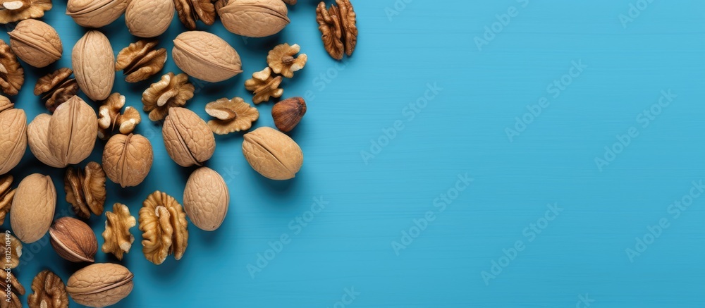 Aufkleber Top view of scattered halves of pulp and whole walnut on a blue background creating a visually pleasing copy space image
